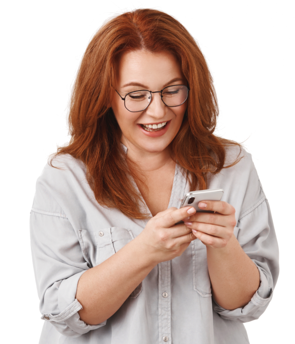 Redhead happy middle-aged modern elegant woman texting husband send funny emoji laughing reading amusing article social media chat friends look smartphone display hold phone wear glasses, white wall.